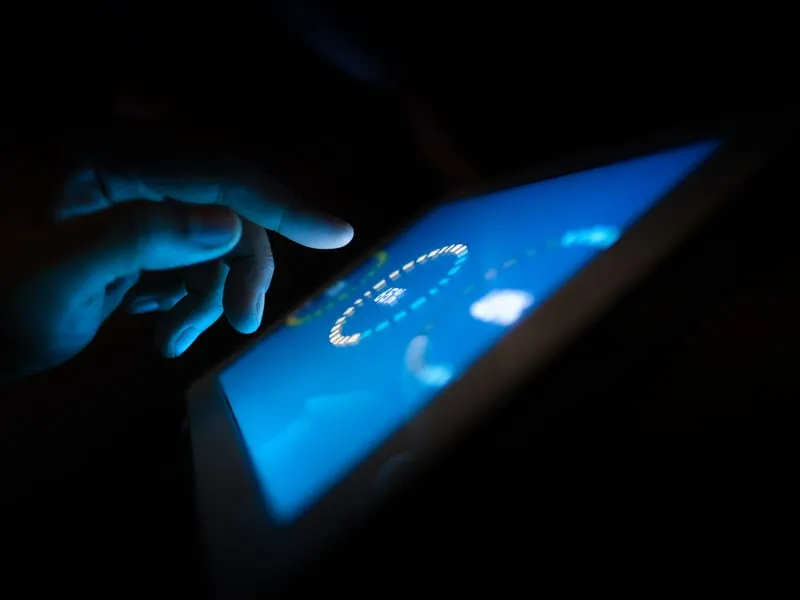 Hand tapping a tablet showing an automated finance dashboard